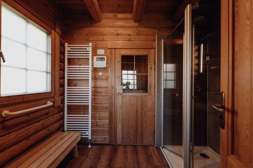 a walk in shower in a wooden room with a bench at Blockhausferien Rügen - Meerblick in Sassnitz