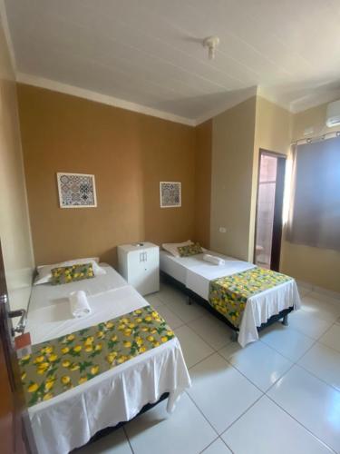 a room with two beds in a room at Sol Hostel & Pousada Maragogi in Maragogi