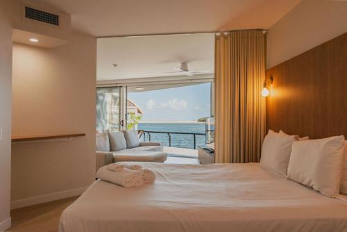 a bedroom with a bed with a view of the ocean at La Promenade Absolute Waterfront Apartments in Caloundra