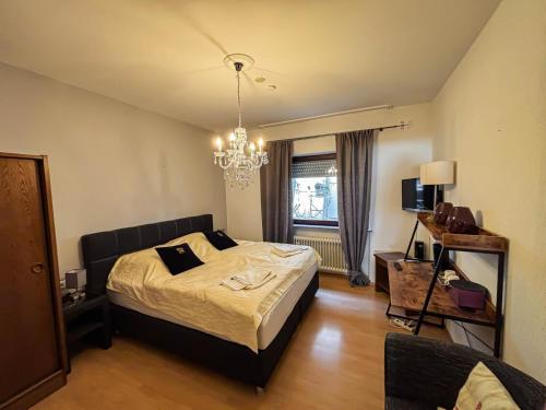 a bedroom with a bed and a chandelier at Hotel Zunftstube in Saarburg