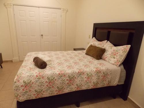 a bedroom with a bed with a floral bedspread and pillows at La Sierra Departamento 1 in Ciudad Juarez