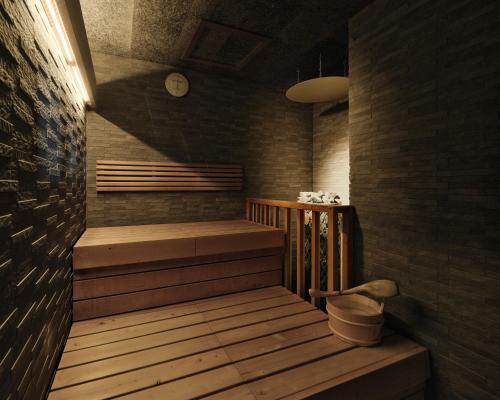a sauna with a bench and a clock on the wall at Candeo Hotels Chino in Chino
