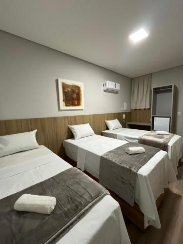 a hotel room with three beds in it at Hotel Almeida in Montes Claros
