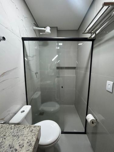 a bathroom with a toilet and a glass shower at Hotel Almeida in Montes Claros