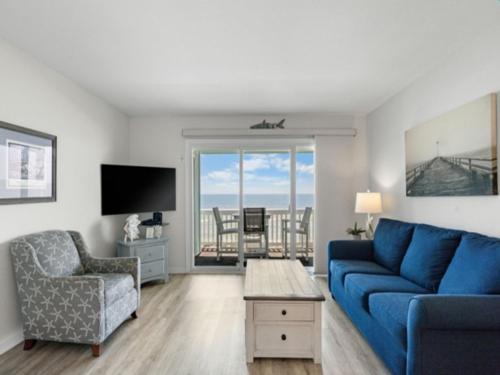 a living room with a blue couch and a chair at A Beach Dream condo in Carolina Beach
