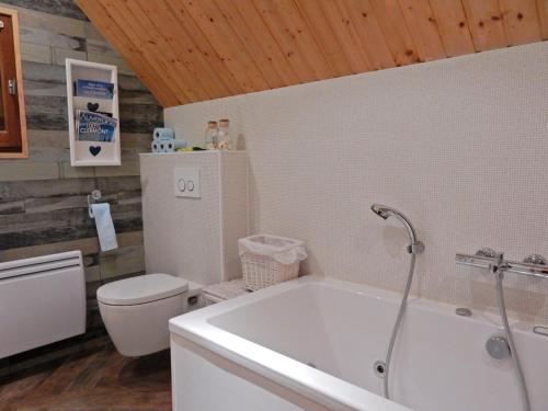 a bathroom with a white tub and a toilet at Poolside Bliss Near Lake in Beaulieu