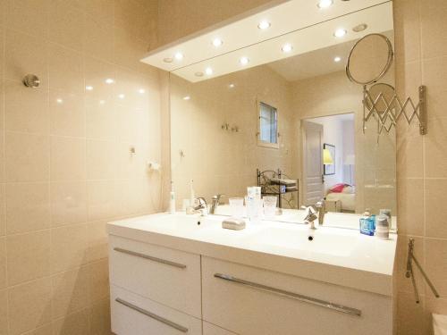 a bathroom with a sink and a large mirror at Rouzède Villa with Pool in La Séguinie
