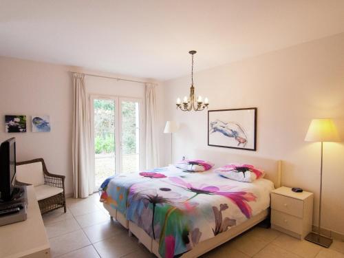 a bedroom with a bed and a chandelier at Rouzède Villa with Pool in La Séguinie