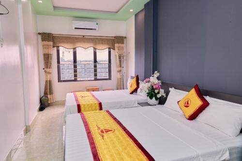 two beds in a room with a window at Huong Cang Sea View Hotel in Cat Ba