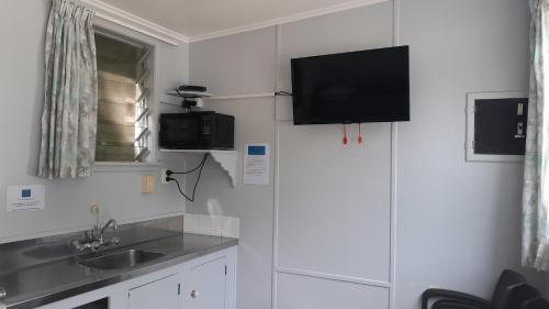 a kitchen with a sink and a tv on the wall at Dickson Holiday Park in Thames