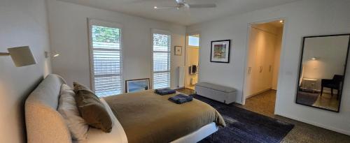a bedroom with a bed with a couch and a mirror at Marittimo in Point Lonsdale