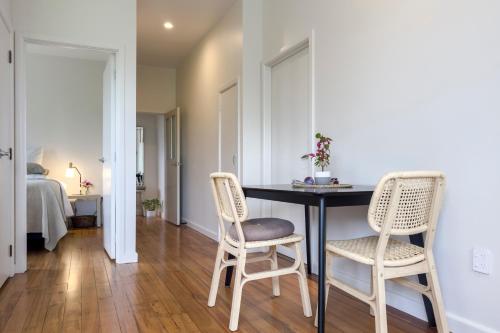 a room with a table and two chairs and a bed at Puna BnB in Matamata