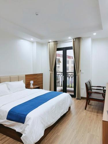 a bedroom with a large bed and a balcony at Cheng Hotel - 怀庄酒店 in Hòa Ðình