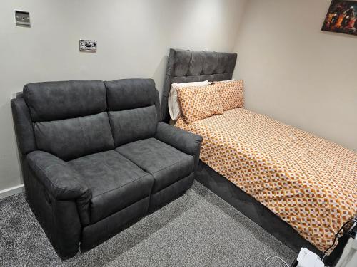 a bed and a couch in a room at Double En Suite Room Newcastle Upon Tyne in Derwent Haugh