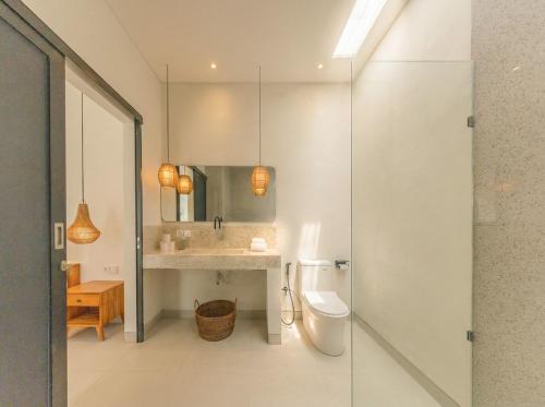 a bathroom with a toilet and a sink and a mirror at Nirvana Canggu 2BR Near Berawa in Mantaak