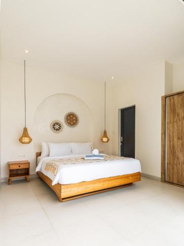 a bedroom with a large bed and pendant lights at Nirvana Canggu 2BR Near Berawa in Mantaak