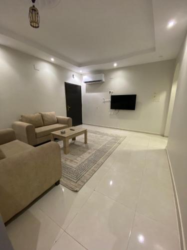 a living room with a couch and a tv at مساكن اركان in Quai