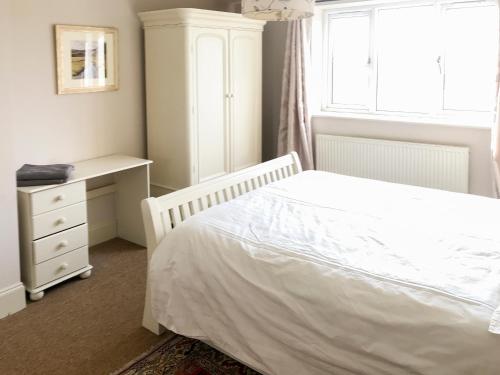a bedroom with a bed and a desk and a window at York House in Richmond