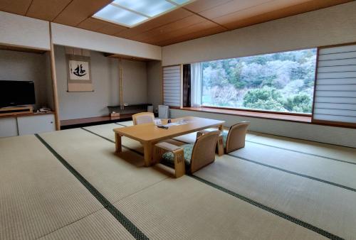 a room with a table and chairs and a large window at Yumoto Fujiya Hotel in Hakone