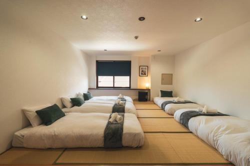 a row of beds in a room at Adamo Akakura in Myoko