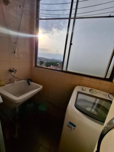 a bathroom with a sink and a window at Apartmento Moto GP in Goiânia