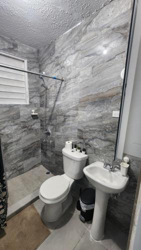 a bathroom with a toilet and a sink at JG Residences in San Juan