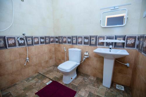 a bathroom with a toilet and a sink at River Shade Inn in Tissamaharama