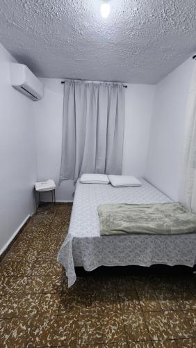a bedroom with a bed in a white room at JG Residences in San Juan