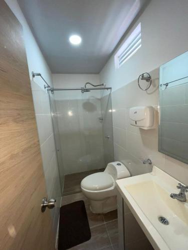 a bathroom with a shower and a toilet and a sink at Hotel Limaco in Neiva