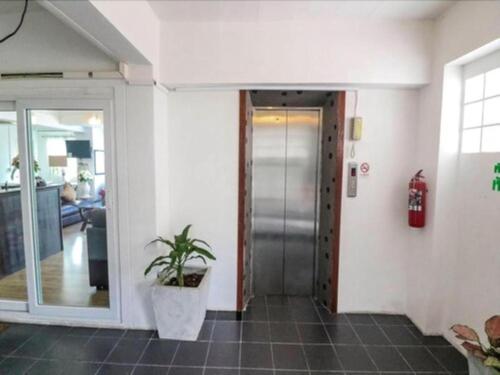 a hallway with a door and a potted plant at Hotel De Ratt in Phuket