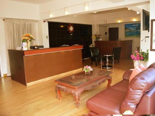 a waiting room with a couch and a table at Hotel De Ratt in Phuket