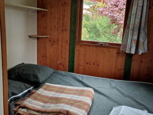 a bed in a room with a window at Chalet avec terrasse - 6 pers. - API-1-52-2030 in La Tour-dʼAuvergne