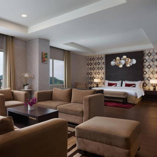 a hotel room with a bed and a living room at Grande Padjadjaran Hotel in Kamparganya