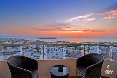 a balcony with two chairs and a view of the ocean at Gated Community Oceanview Condo Pool & Gym in La Paz