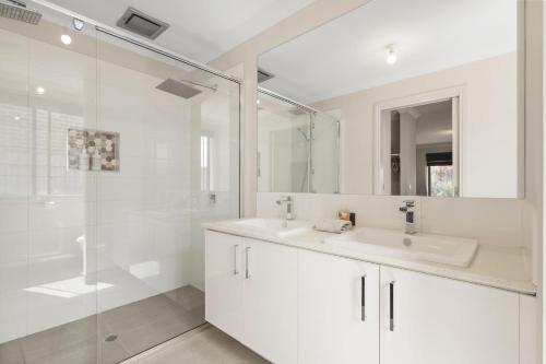 a white bathroom with a sink and a shower at Paradise Point Cowes in Cowes