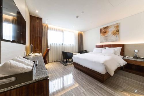 クリにあるFirst Hotelの大きなベッドと机があるホテルの部屋