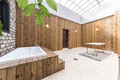 クリにあるFirst Hotelの木製の壁の部屋にある浴槽
