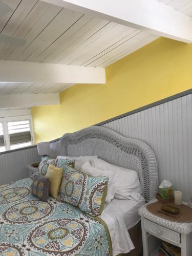 a bedroom with a bed and a yellow wall at Tropical Oasis in Christiansted