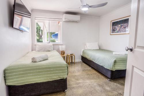 a bedroom with two beds and a ceiling fan at Relax at 42 Cape View Resort in Broadwater