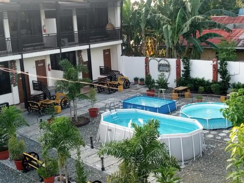 a hotel with two pools and palm trees at Cuna Del Alri in Samal