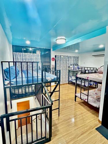 a room with three bunk beds and a blue ceiling at Cuna Del Alri in Samal