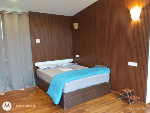 a bedroom with a bed with a wooden wall at The Brookshore in Kodaikānāl