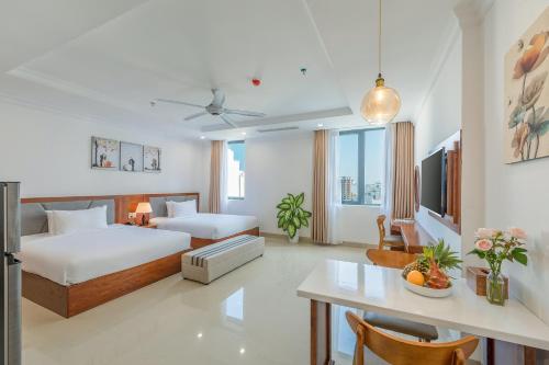 a hotel room with a bed and a dining room at Kiwi Beachside Hotel & Cafe Da Nang in Danang