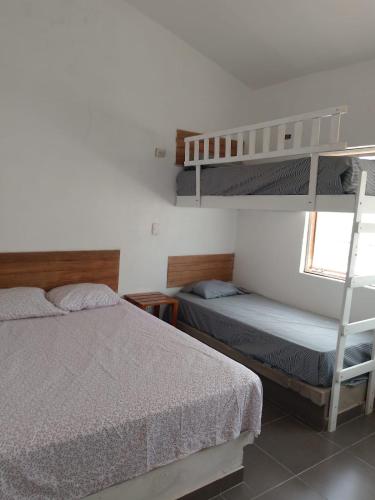 a bedroom with two bunk beds and a ladder at Casa los Pinos in Zorritos