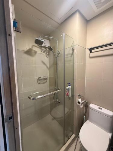 a bathroom with a glass shower with a toilet at LuxeRN Suite at S Residences in Manila