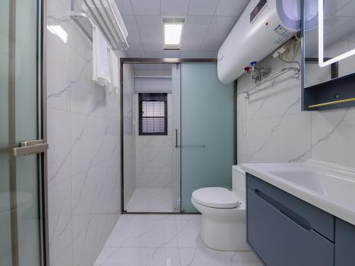 a bathroom with a shower and a toilet and a sink at Annie Apartment 2105 in Kunming