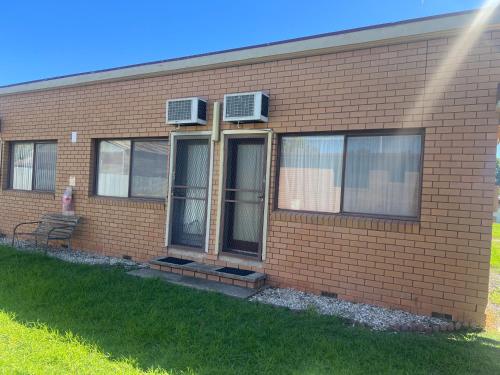 a brick building with two air conditioners on it at Walla Walla Hotel Motel in Walla-Walla