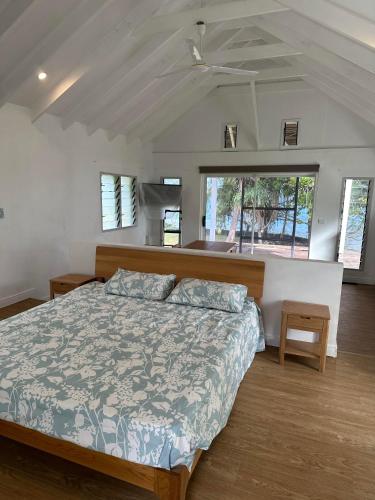 a bedroom with a large bed and some windows at Vila Del Mare Oceanfront Villas in Port Vila