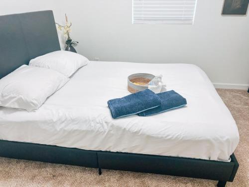 a bed with two towels and a basket on it at Saffire Villa Rooms in Tacoma