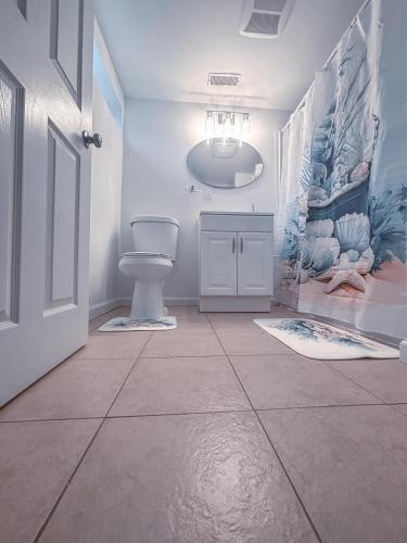 a bathroom with a toilet and a tile floor at Saffire Villa Rooms in Tacoma